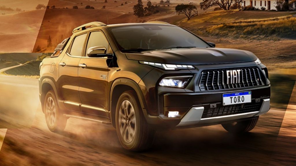 Picape Fiat Toro de cor preta em terreno de terra, destacando a frente imponente e os faróis em LED; um dos modelos mais vendidos da linha de carros da fiat.
