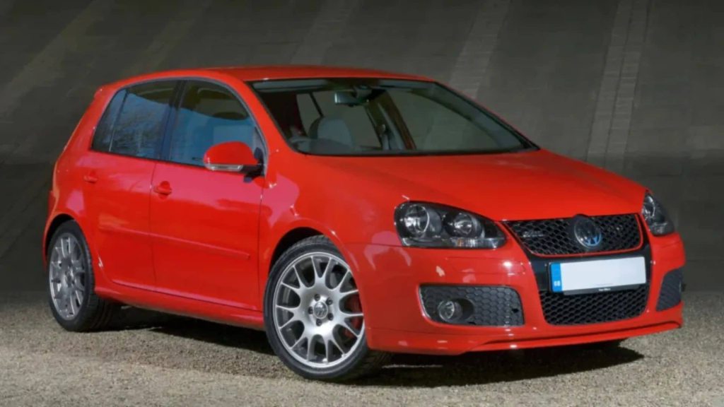 Carro vermelho do modelo golf com fundo cinza.