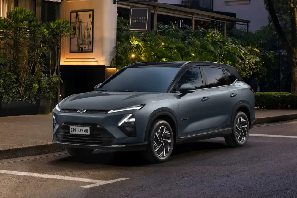 Carro elétrico cinza do modelo Captiva Ev com design moderno e estacionado em frente a um shopping.