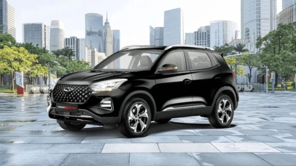 Carros híbridos: Chery Tiggo 5X PRO preto, um SUV híbrido, estacionado em um cenário urbano moderno com arranha-céus.