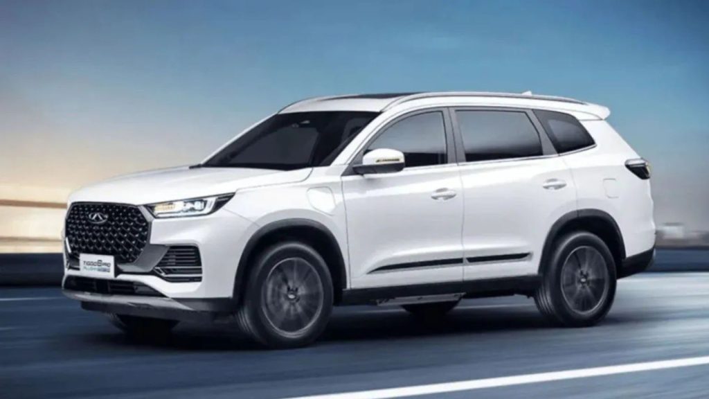 Carros híbridos: SUV Chery Tiggo 8 Pro, branco, em movimento sobre uma estrada com um céu e nuvens no fundo.