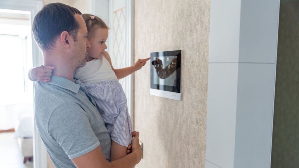 homem com criança no colo utilizando um tablet