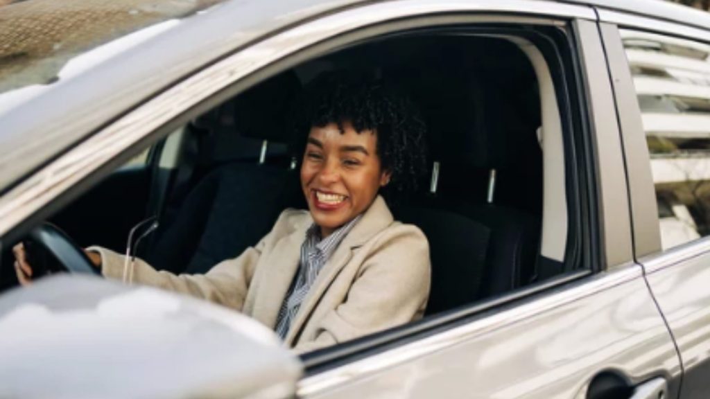 mulher dentro de um carro sorrindo pela janela