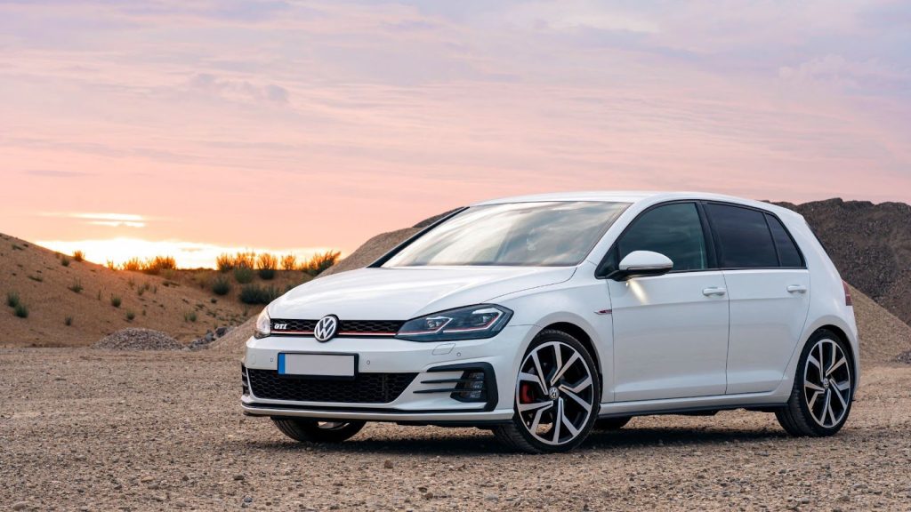 Volkswagen Golf branco em ambiente externo com pôr do sol. Um dos melhores carros com teto solar até 50 mil seminovos