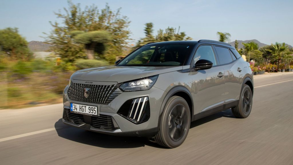 Novo Peugeot 2008 2025 cor Cinza Selenium em movimento destacando luzes LED Garra de Leão e teto bitom.