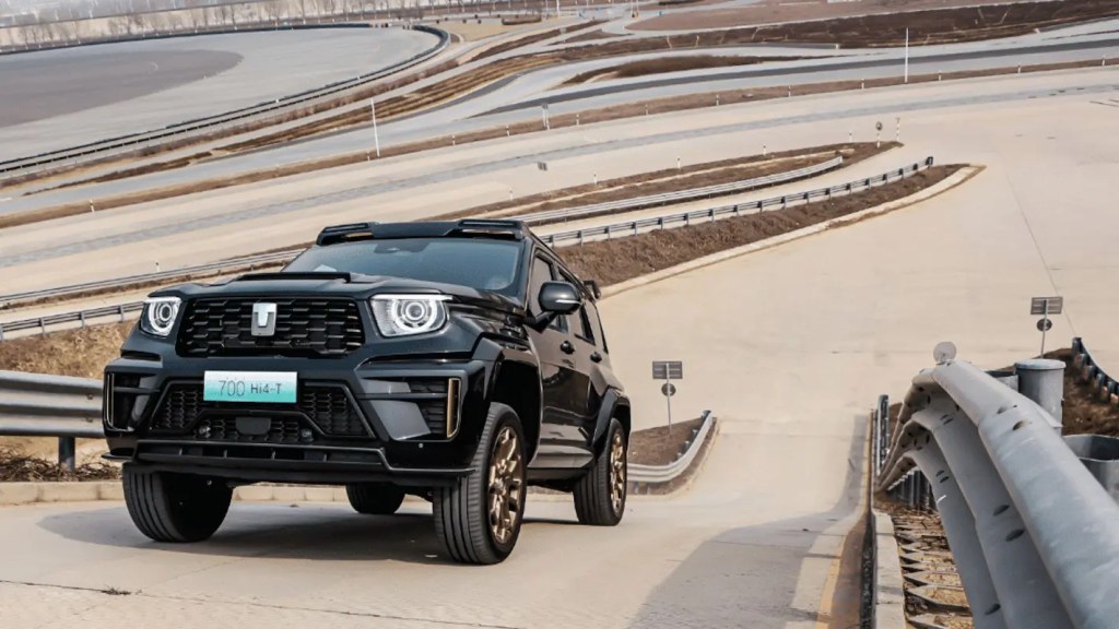 Carro GWM Tank 700 preto subindo um aclive.