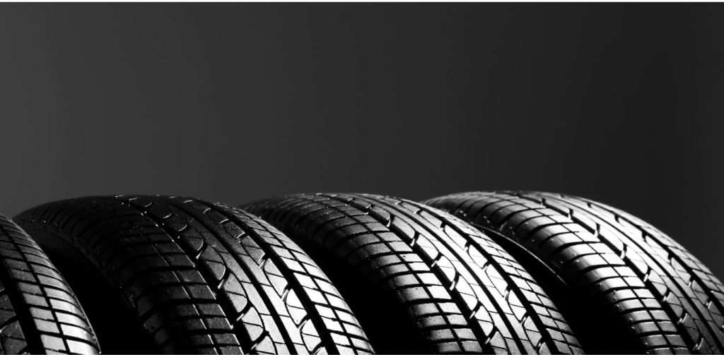 Quatro pneus automotivos alinhados lado a lado em fundo escuro, destacando os sulcos da banda de rodagem e a tecnologia pneu seal inside, associada a segurança e resistência a perfurações.