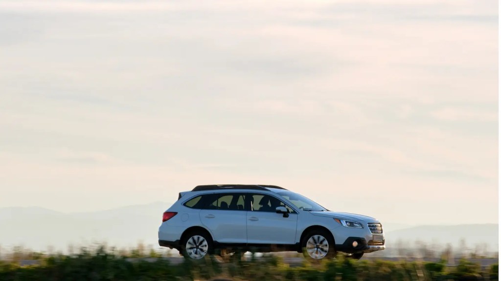 SUV branco dirigindo em estrada aberta ao entardecer transmite conforto, estabilidade e versatilidade, ilustrando os melhores SUVs para viagens, uso diário, espaço interno e desempenho.