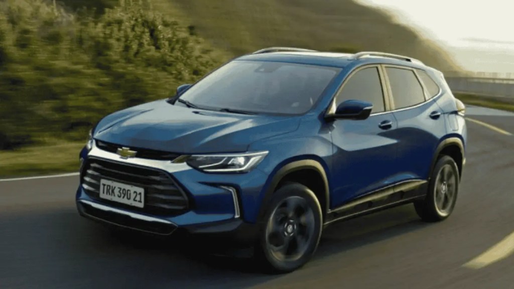 Carro do modelo Chevrolet Tracker azul rodando em estrada como opção de SUV até 120 mil.
