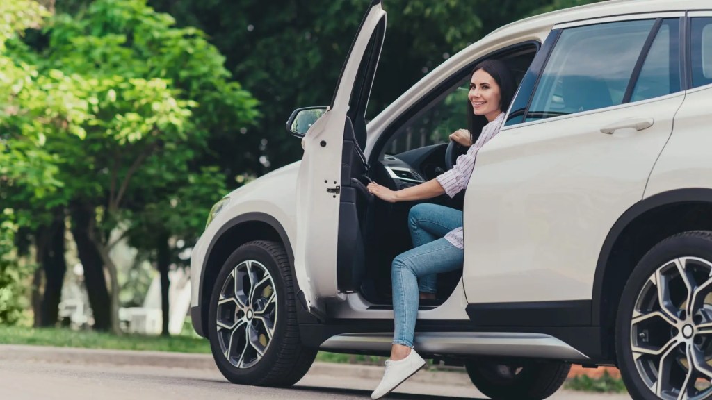 Mulher satisfeita após test drive, etapa crucial de como saber se estou comprando um bom carro seminovo.