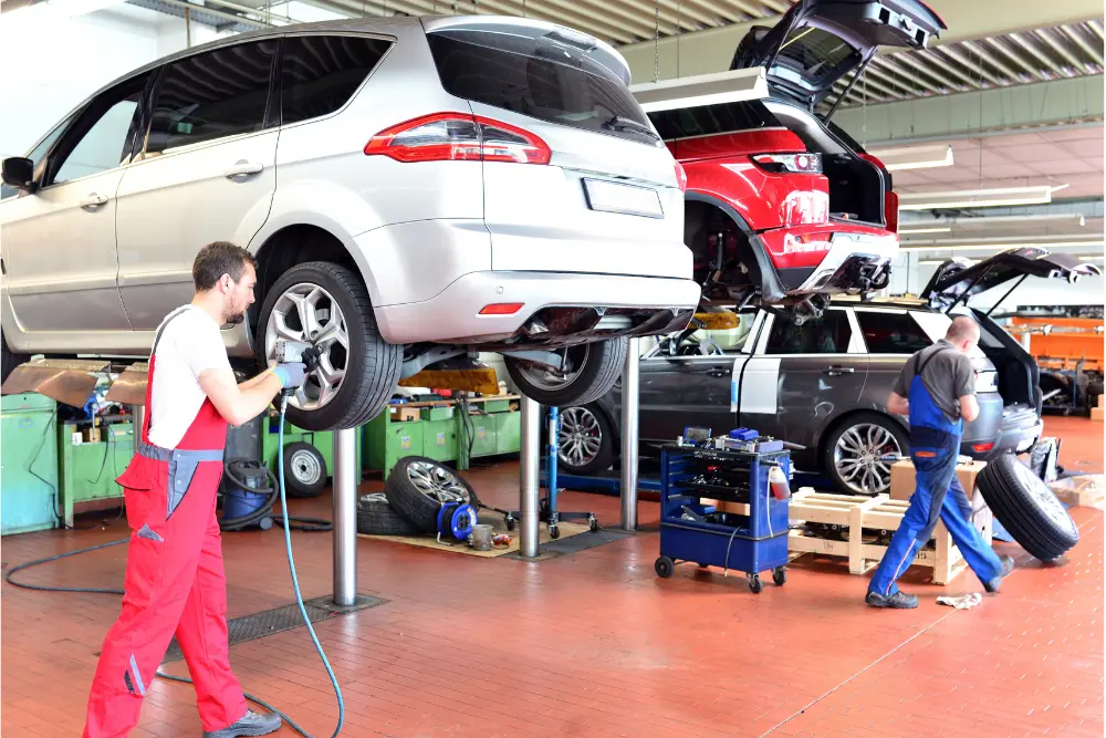 Oficina mecânica realizando manutenção automotiva no guia de carro seminovos sp, com veículos elevados e revisão técnica.