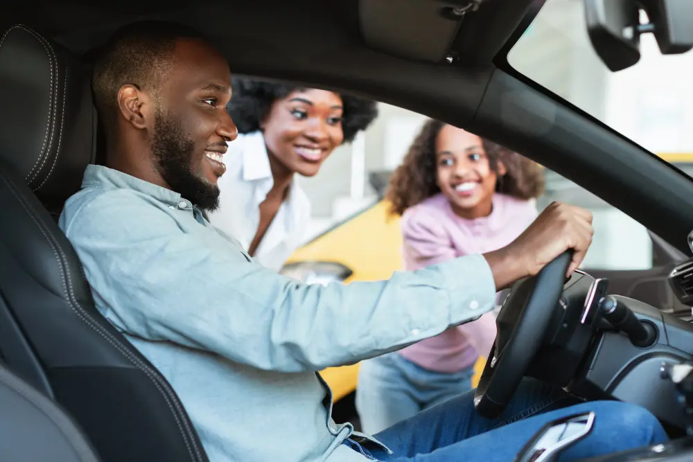 Família analisando o que saber antes de comprar um carro seminovo durante avaliação interna e teste do veículo.